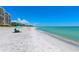 Idyllic beach scene with turquoise waters, white sand, and condo building in the background on a clear, sunny day at 534 Sutton Pl, Longboat Key, FL 34228