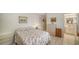 Bright bedroom featuring a floral bedspread, art, and a quaint bathroom entrance at 534 Sutton Pl, Longboat Key, FL 34228