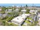 An aerial view of a condo/townhouse nestled in a community surrounded by lush greenery and a serene pond at 534 Sutton Pl, Longboat Key, FL 34228