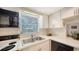 Kitchen with stainless steel sink, white backsplash, and view into the dining area at 534 Sutton Pl, Longboat Key, FL 34228