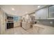Kitchen area featuring stainless steel sink, white cabinets, tile floors, and seamless access to dining area at 534 Sutton Pl, Longboat Key, FL 34228