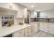 Bright kitchen with white cabinets, tile floors, and countertops, and seamless access to dining area at 534 Sutton Pl, Longboat Key, FL 34228