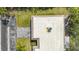 An aerial roof view of a townhouse with a light-colored roof, a well-kept lawn, and an asphalt driveway at 534 Sutton Pl # V-1, Longboat Key, FL 34228