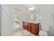 Bathroom features a vanity with cabinets, large mirror, and tiled floors with an exit door at 5342 98Th E Ave, Parrish, FL 34219