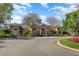 Elegant clubhouse with stone accents, arched entrances, manicured landscaping, and ample parking under a bright, partly cloudy sky at 5342 98Th E Ave, Parrish, FL 34219