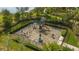 Aerial view of a fenced-in community playground featuring climbing equipment, slides, and play structures at 5561 Sentiero Dr, Nokomis, FL 34275