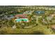 Aerial view of community pool, tennis courts, landscaping, and manicured lawn at 5561 Sentiero Dr, Nokomis, FL 34275