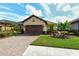 Beautiful property with manicured lawn, paver driveway, and lush plantings at 5561 Sentiero Dr, Nokomis, FL 34275