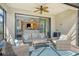 Comfortable covered patio with ceiling fan and wicker furniture, seamlessly connected to the interior living space at 5561 Sentiero Dr, Nokomis, FL 34275