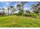 Expansive backyard featuring mature trees, well-maintained lawn, and beautiful greenery at 5614 Garden Lakes Dr, Bradenton, FL 34203