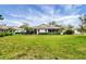 Backyard featuring well-manicured lawn, mature landscaping, and the home's exterior at 5614 Garden Lakes Dr, Bradenton, FL 34203