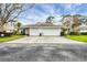 A well-maintained home featuring a double garage door and a spacious driveway with beautiful landscaping at 5614 Garden Lakes Dr, Bradenton, FL 34203
