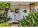 Charming front entrance featuring decorative plants, a wreath, and a fish decoration by the door at 5614 Garden Lakes Dr, Bradenton, FL 34203