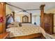Luxurious main bedroom with a decorative four-poster bed, dresser, and ample natural light at 5614 Garden Lakes Dr, Bradenton, FL 34203