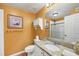 Bright bathroom with granite countertop vanity, decorative accents, and a tiled shower at 5700 Bentgrass Dr # 209, Sarasota, FL 34235