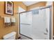 Bathroom with white tiled shower, glass doors, and modern fixtures at 5700 Bentgrass Dr # 209, Sarasota, FL 34235