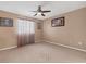Neutral bedroom featuring a ceiling fan, patterned carpet, and sheer curtains at 5700 Bentgrass Dr # 209, Sarasota, FL 34235