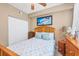Comfortable bedroom complete with ceiling fan, natural wood furniture, and plush pillows at 5700 Bentgrass Dr # 209, Sarasota, FL 34235