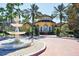 Beautiful clubhouse exterior with brick walkway and fountain in a lush, tropical setting at 5700 Bentgrass Dr # 209, Sarasota, FL 34235