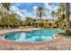 Large in-ground community pool with brick paver surround, lounge chairs, and covered pergola at 5700 Bentgrass Dr # 209, Sarasota, FL 34235