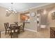 Dining area with a view to the kitchen featuring tile flooring and a modern chandelier at 5700 Bentgrass Dr # 209, Sarasota, FL 34235