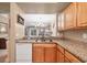 Functional kitchen showcases wood cabinets, granite counters, and an opening to the living space at 5700 Bentgrass Dr # 209, Sarasota, FL 34235