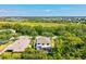 An aerial view shows a screened lanai, a lush backyard, and tree-lined street at 6156 41St E St, Bradenton, FL 34203