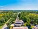 An aerial view showcases a home with a screened lanai and lush green surroundings at 6156 41St E St, Bradenton, FL 34203