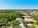 Aerial view of a home in a lush, green neighborhood under a clear blue sky at 6156 41St E St, Bradenton, FL 34203