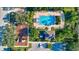 An aerial view showcases a community pool and playground, surrounded by lush greenery and palm trees at 6156 41St E St, Bradenton, FL 34203