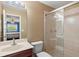 Bathroom featuring a glass shower, toilet, sink with vanity, and view into the bedroom at 6156 41St E St, Bradenton, FL 34203