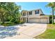 Two-story home featuring a three-car garage, neutral paint, dark shutters, and manicured landscaping at 6156 41St E St, Bradenton, FL 34203