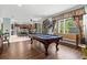 Open-concept game room with billiard table, seamlessly connected to a modern kitchen and bright natural light at 6156 41St E St, Bradenton, FL 34203