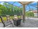 Screened patio with comfortable seating area and fire pit, ideal for outdoor entertaining at 6156 41St E St, Bradenton, FL 34203