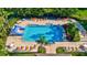 An aerial view showcases the sparkling community pool with a slide, inviting lounge chairs, and lush landscaping at 6156 41St E St, Bradenton, FL 34203