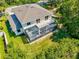 A rear exterior showcases a balcony and screened-in patio with views of the green backyard at 6156 41St E St, Bradenton, FL 34203