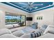 Cozy living room with a sectional sofa, a blue ceiling and a view of the pool at 629 River Enclave Ct, Bradenton, FL 34212