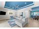 Comfortable living room with a large sectional, accent chair, blue ceiling and an open floor plan to the dining room at 629 River Enclave Ct, Bradenton, FL 34212