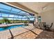 Outdoor pool area with brick patio, screened enclosure and dining area overlooking a lake at 629 River Enclave Ct, Bradenton, FL 34212