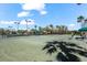 A tennis court with palm trees and shade structures around its perimeter at 629 River Enclave Ct, Bradenton, FL 34212