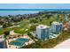 Aerial view showcasing condos, a golf course, tennis courts, and scenic water views at 655 Longboat Club Rd # 16B, Longboat Key, FL 34228