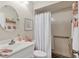 Cozy bathroom with coral decor, a round mirror, and white shower curtain at 7223 Wood Creek Dr # 22, Sarasota, FL 34231