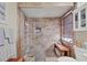 Gorgeous tiled shower with a glass door, a built-in bench, and natural light from the window at 7223 Wood Creek Dr # 22, Sarasota, FL 34231