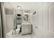 A well-lit bathroom featuring stylish marble floors, a shower and tub combination and a modern vanity at 750 N Tamiami Trl # 604, Sarasota, FL 34236