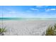 White sand beach with the ocean in the distance at 750 N Tamiami Trl # 604, Sarasota, FL 34236