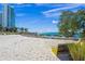 Inviting beach scene with bright white sands, modern seating, and a towering building on the horizon at 750 N Tamiami Trl # 604, Sarasota, FL 34236