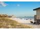 Wide sandy beach with people enjoying the day, with a lifeguard stand in the foreground at 750 N Tamiami Trl # 604, Sarasota, FL 34236