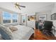 Bedroom featuring hardwood floors, natural light, and a workspace with a modern ceiling fan at 750 N Tamiami Trl # 604, Sarasota, FL 34236