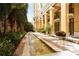 Beautiful building exterior showcasing a tranquil water feature and lush landscaping at 750 N Tamiami Trl # 604, Sarasota, FL 34236