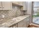 Kitchen featuring granite countertops, sleek cabinets, stainless steel faucet, and a window view at 750 N Tamiami Trl # 604, Sarasota, FL 34236